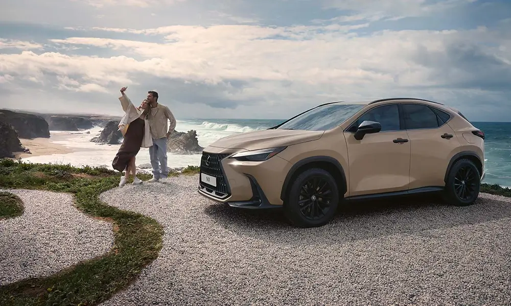 Lexus NX zaparkowany na wybrzeżu z dwiema osobami w tle